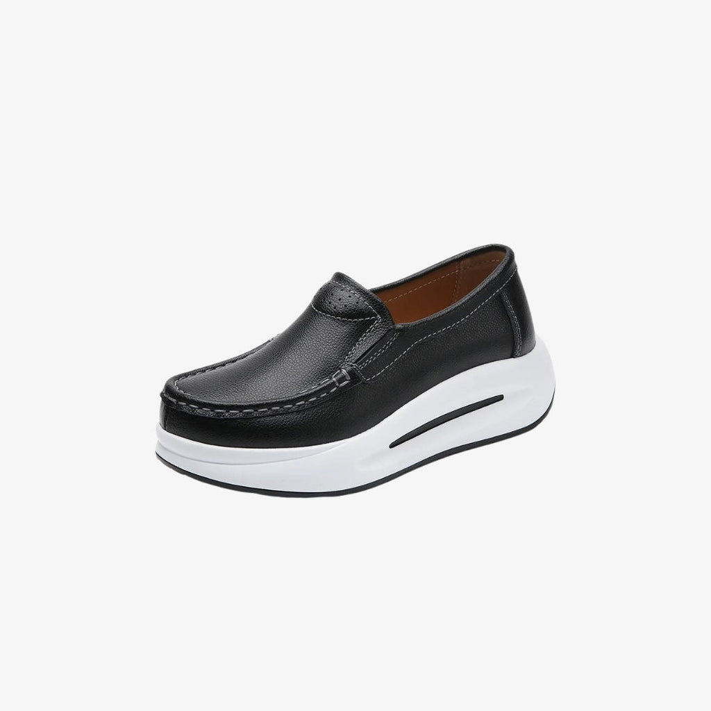 Mocassini da donna in pelle nera con suola spessa bianca per uno stile moderno e comodo. Il design minimalista include cuciture a vista e una calzata facile, perfetti per un look elegante e al tempo stesso casual.