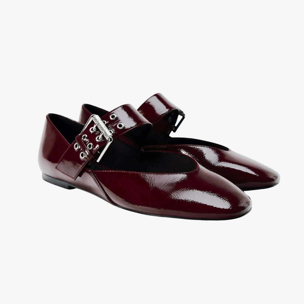 Mocassino ballerina in vernice bordeaux stile vintage, con una maxi fibbia, su sfondo grigio