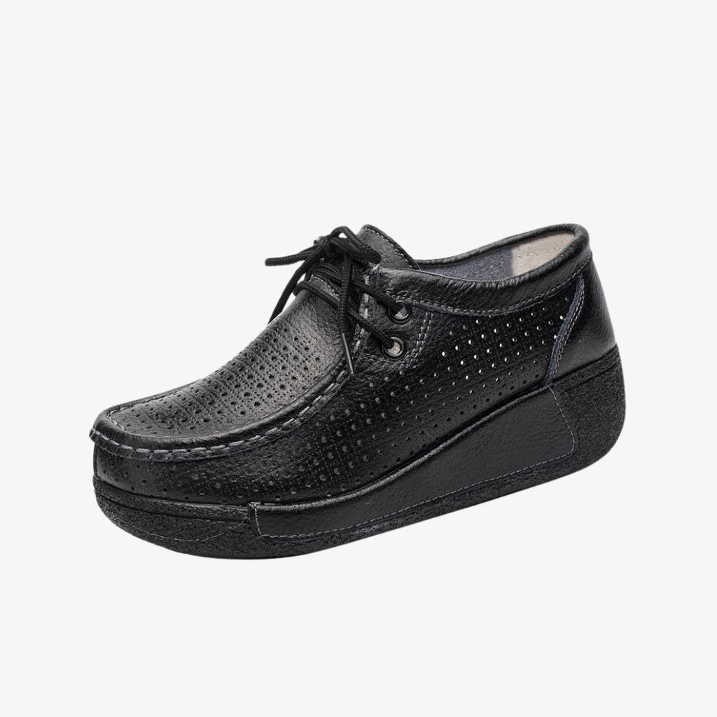 Mocassini donna in pelle nera, dal design traforato per una migliore aerazione. Dotate di lacci per una regolazione precisa, queste scarpe eleganti hanno suole con zeppa nere che offrono un buon sostegno e un comfort ottimale per tutta la giornata.
