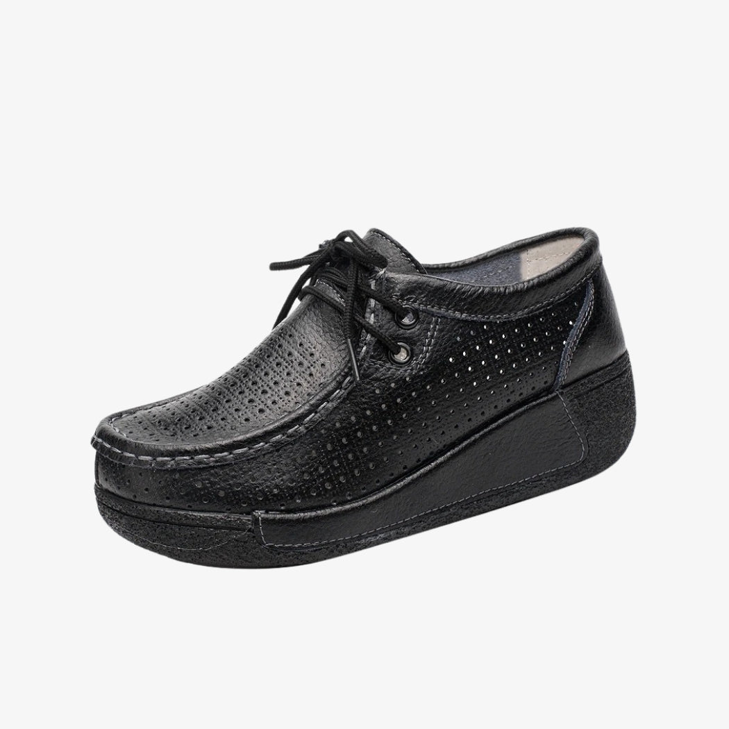 Mocassini donna in pelle nera, dal design traforato per una migliore aerazione. Dotate di lacci per una regolazione precisa, queste scarpe eleganti hanno suole con zeppa nere che offrono un buon sostegno e un comfort ottimale per tutta la giornata.