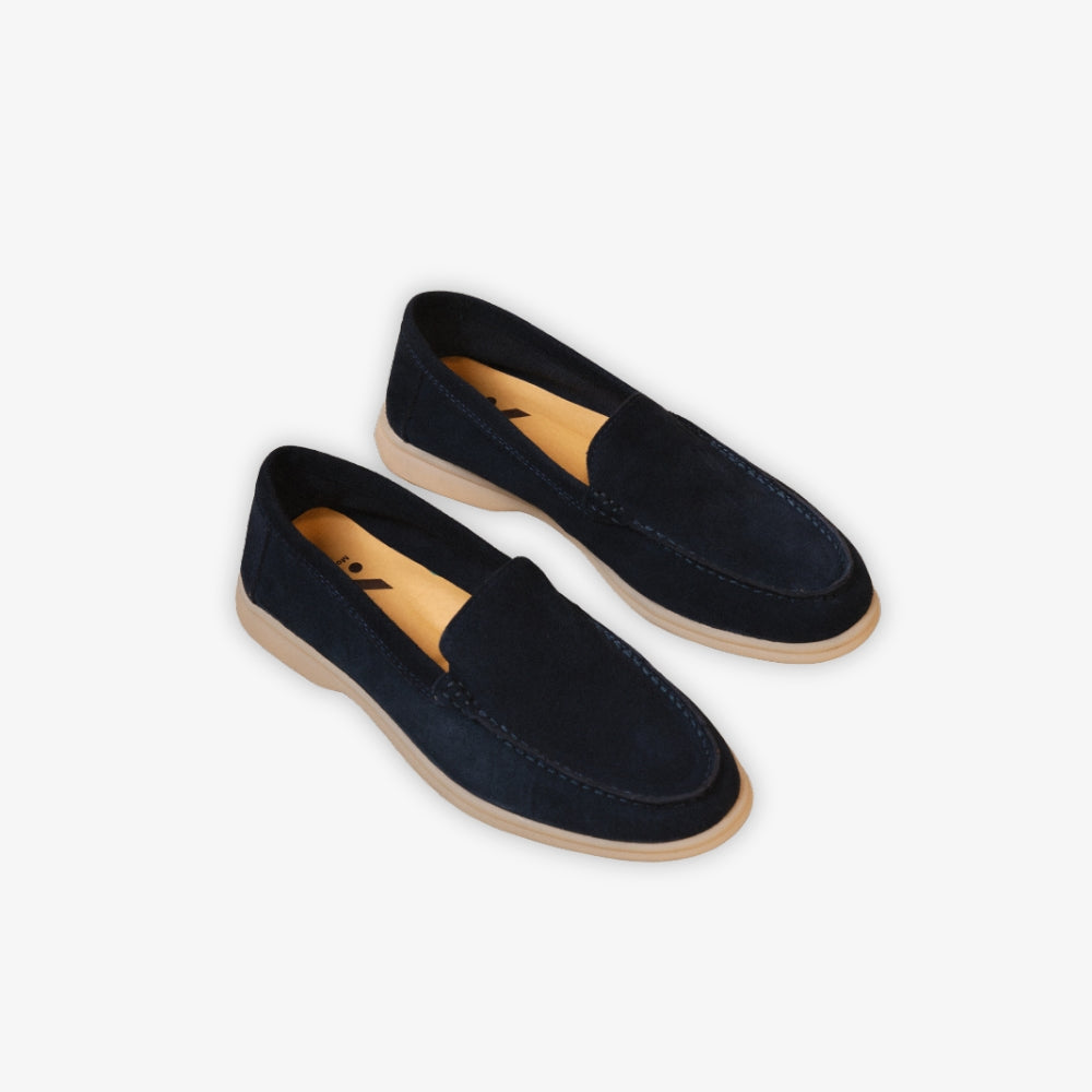 mocassino yacht blu appoggiato a terra su sfondo beige