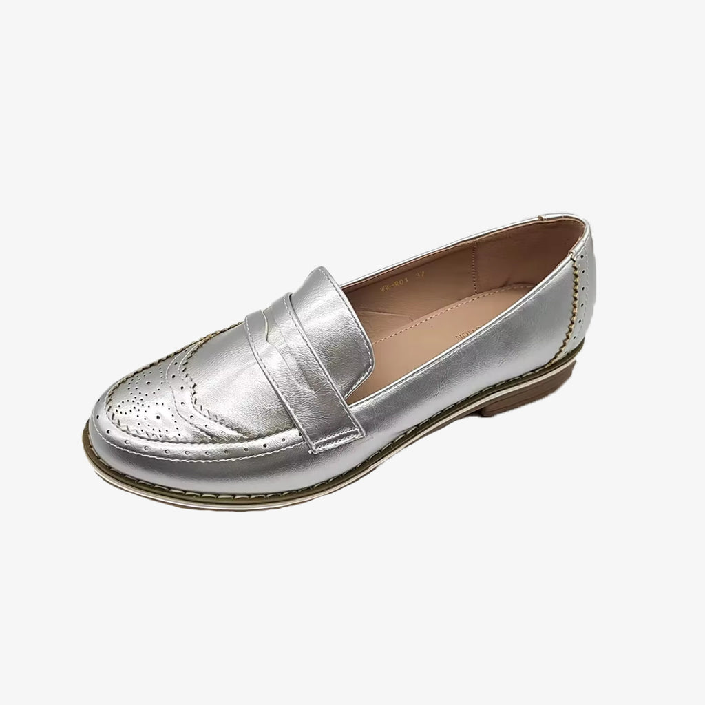 Un mocassino argento chic da donna su sfondo bianco uniforme