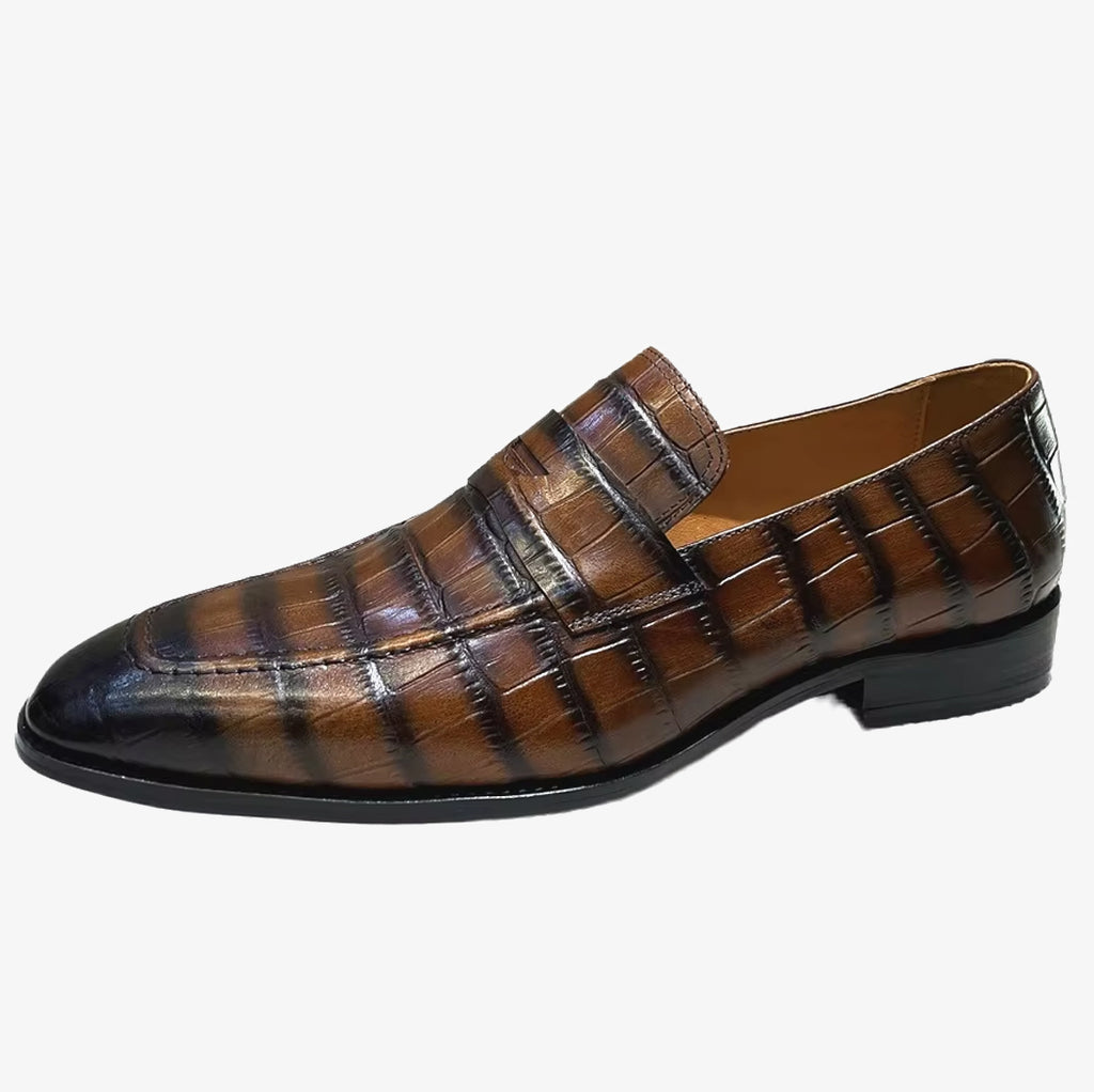 Un mocassino italiano da uomo in pelle effetto coccodrillo su sfondo bianco uniforme