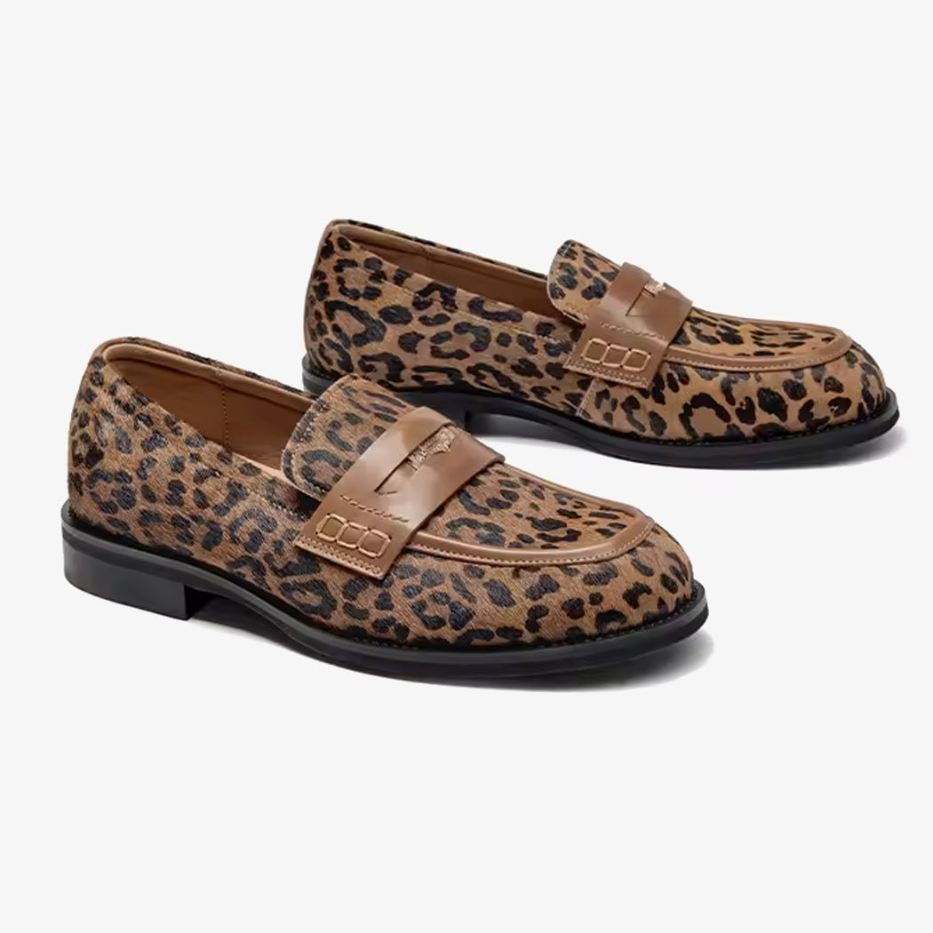 Paio di mocassini in pelle leopardata con cinturino sul dorso del piede su sfondo bianco