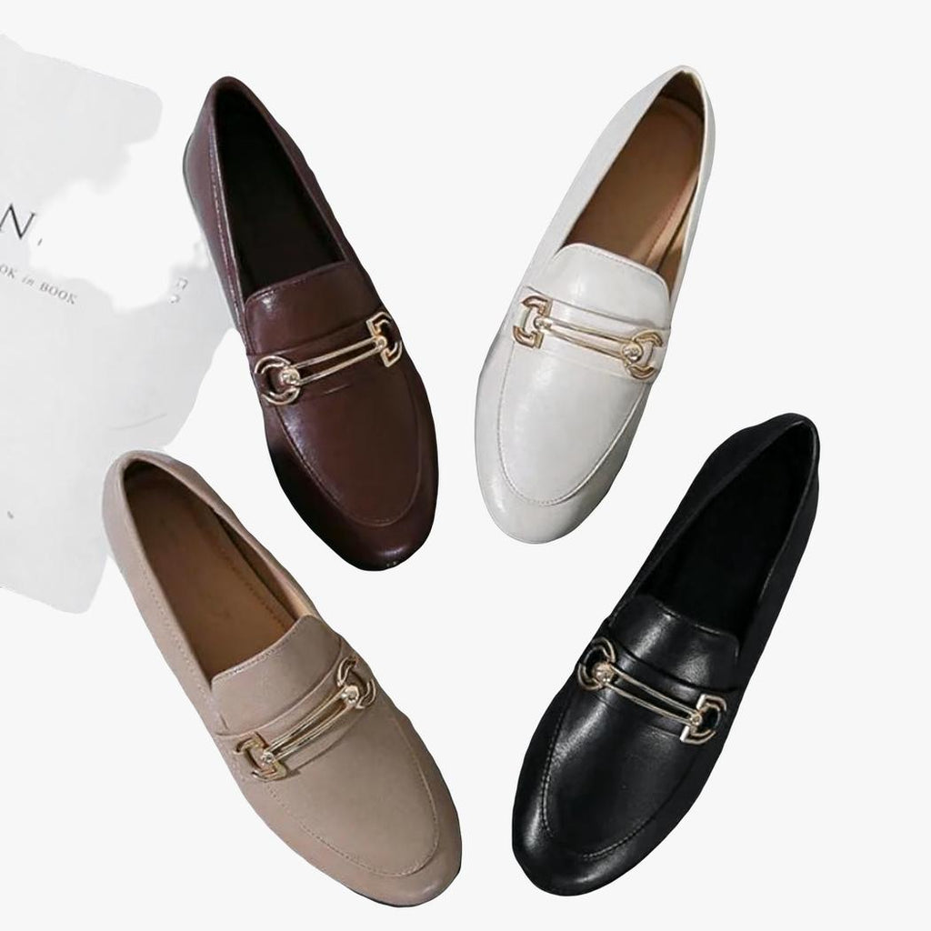 su sfondo grigio chiaro si vedono 4 mocassini eleganti con tacco quadrato in pelle sintetica da donna, ognuno di un colore diverso: bianco, nero, marrone e beige.