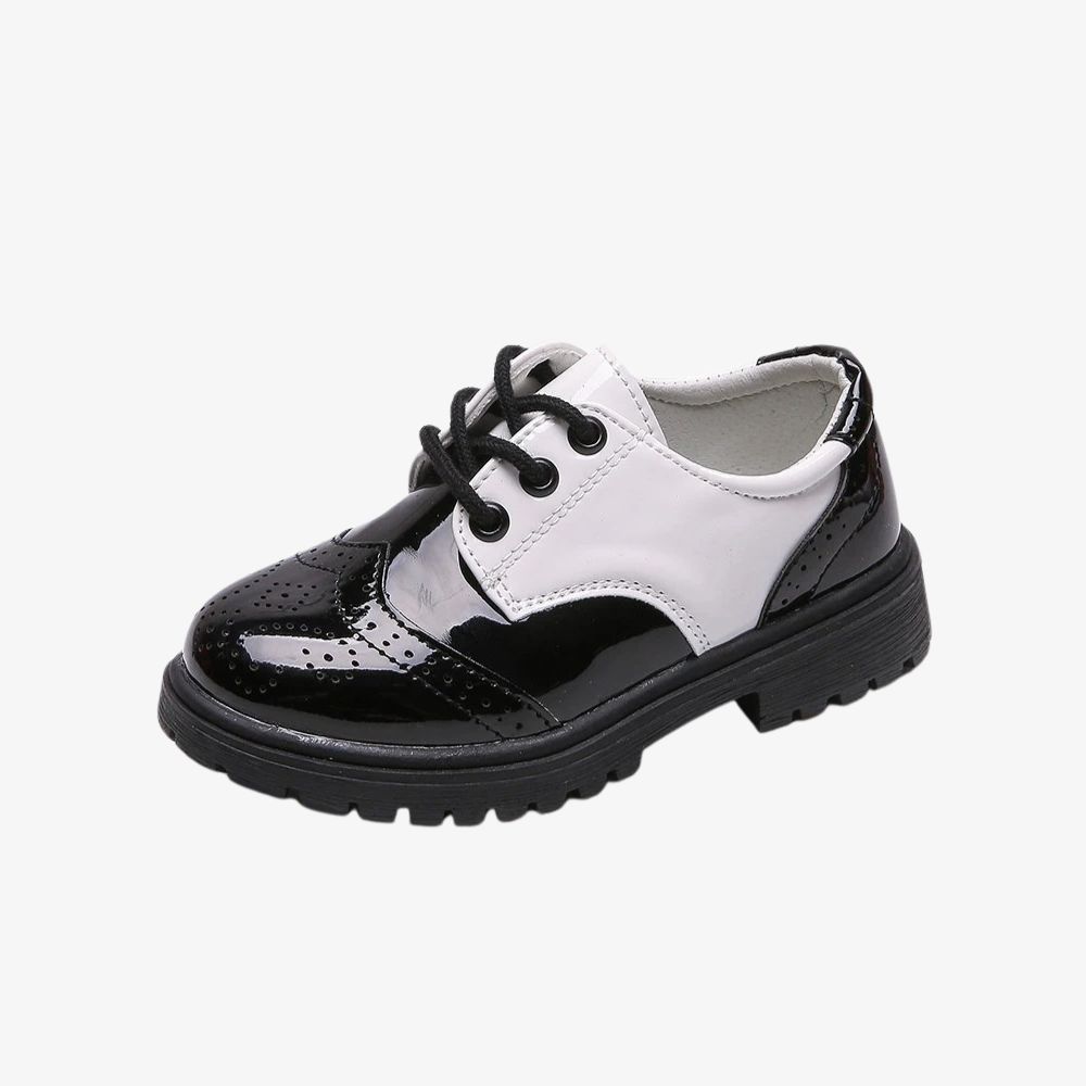 Un mocassino chiuso da bambino, nero lucido con una parte bianca