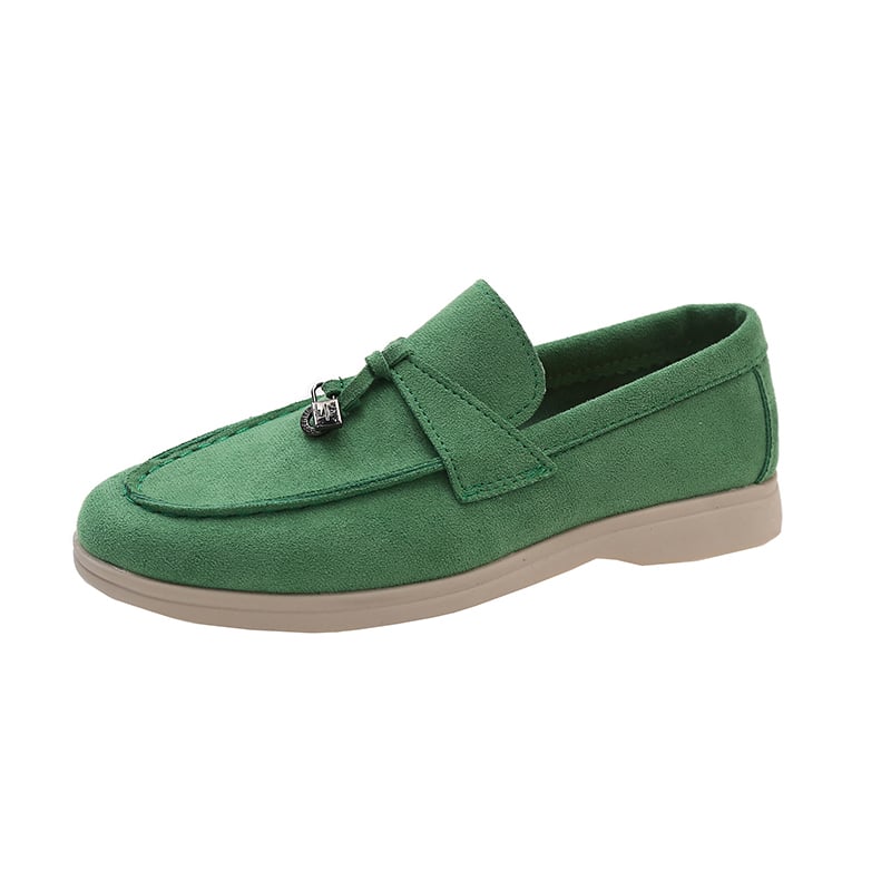 Mocassino in pelle scamosciata verde con suola beige su sfondo bianco