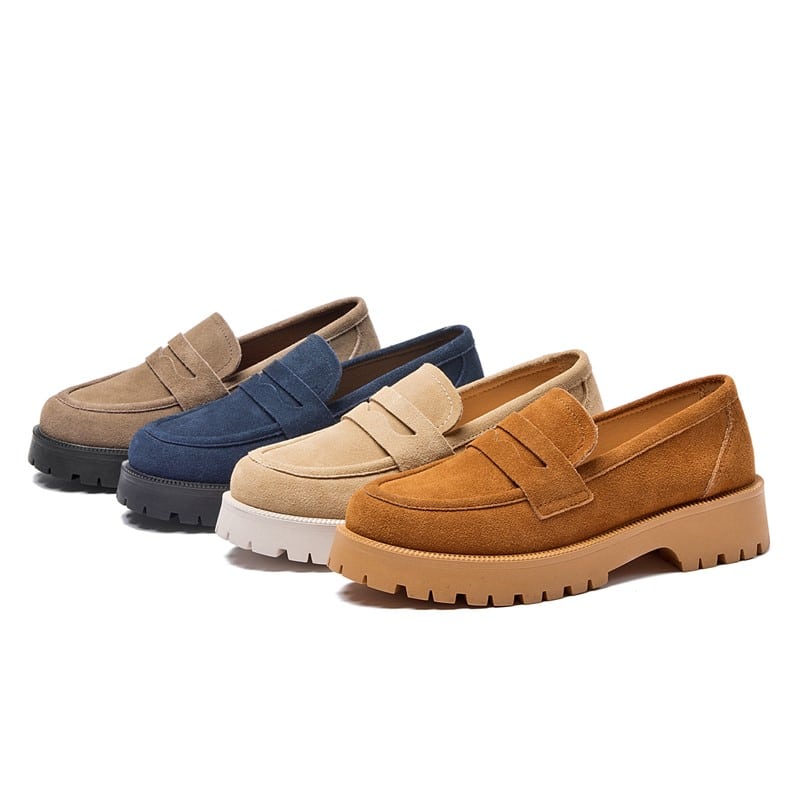 Quattro semplici mocassini in pelle scamosciata di colori diversi, grigio-blu-beige e marrone, con suole spesse allineate su uno sfondo bianco.