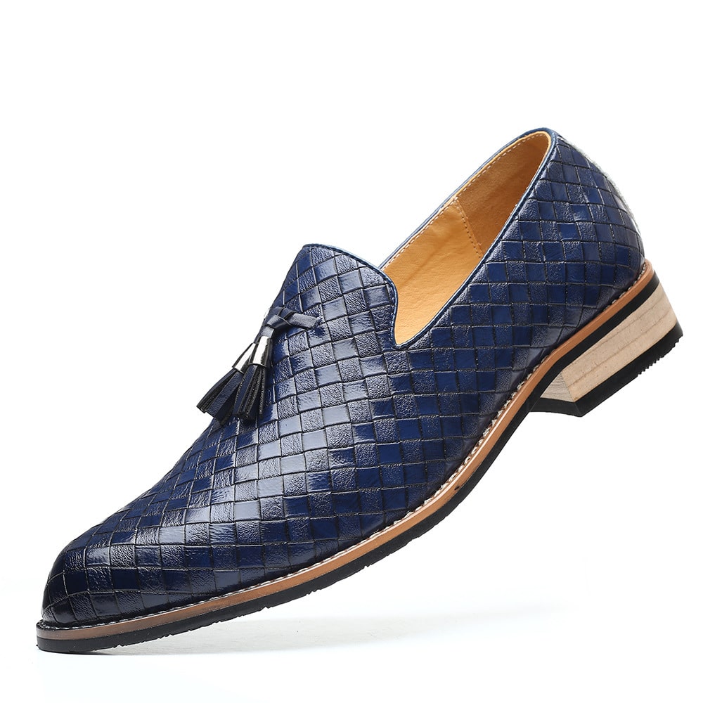 Un mocassino in pelle intrecciata blu con suola chiara e nappe decorative su sfondo bianco.