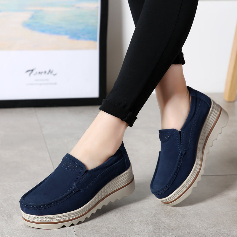 mocassino con zeppa in finto camoscio blu indossato da una donna