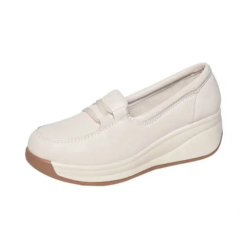 Mocassino bianco con zeppa su sfondo bianco.