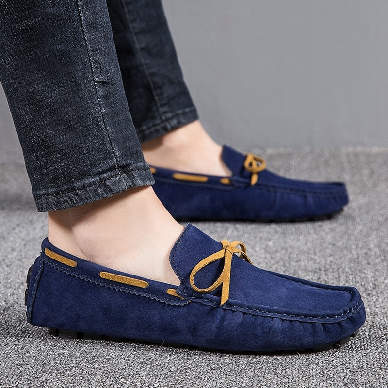 Piedi di un uomo di profilo che indossa jeans e mocassini classici da barca blu