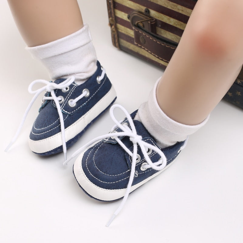 Gambe di bambino che indossano calzini bianchi e mocassini blu stile barca
