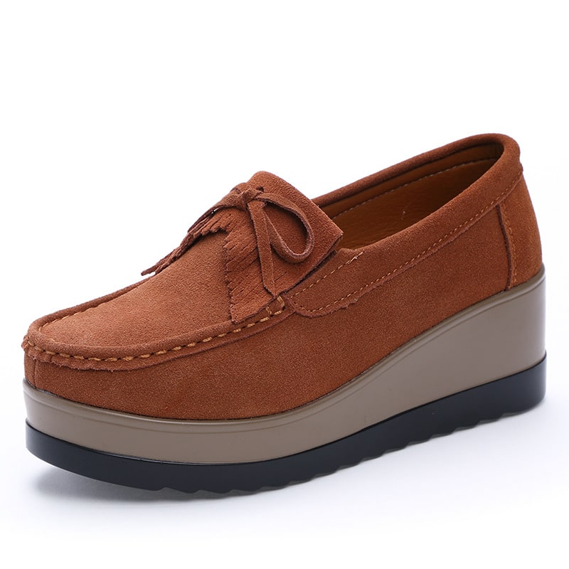 Mocassino con piattaforma marrone con sfondo bianco.