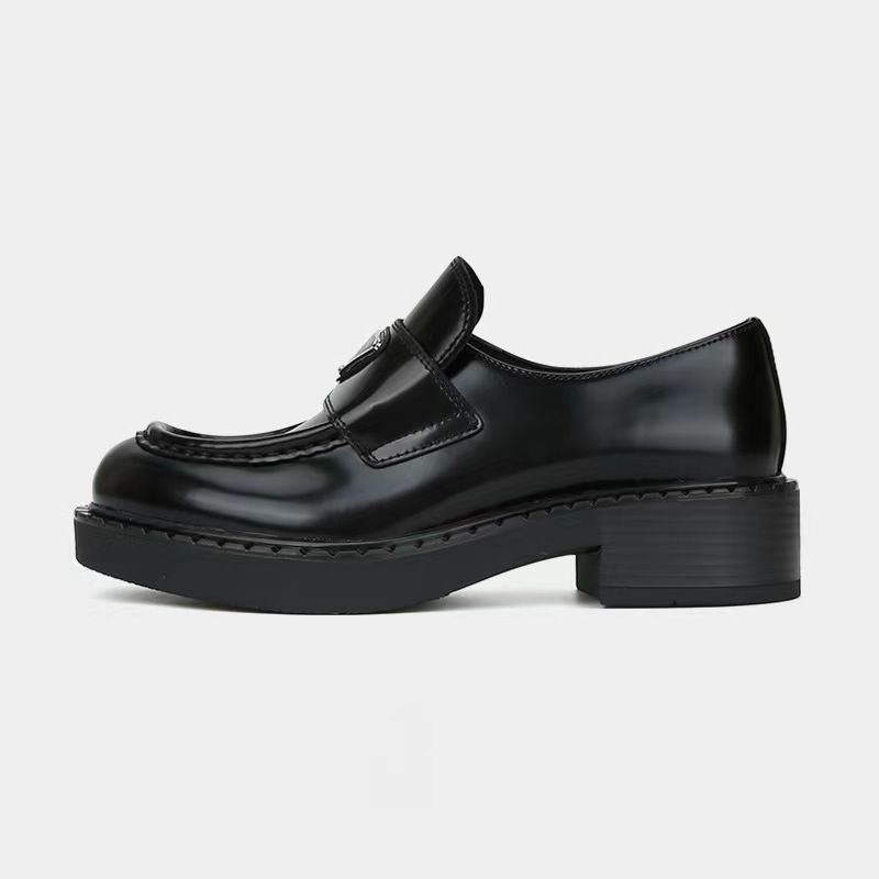 mocassino in pelle nera con tacco piccolo su sfondo bianco
