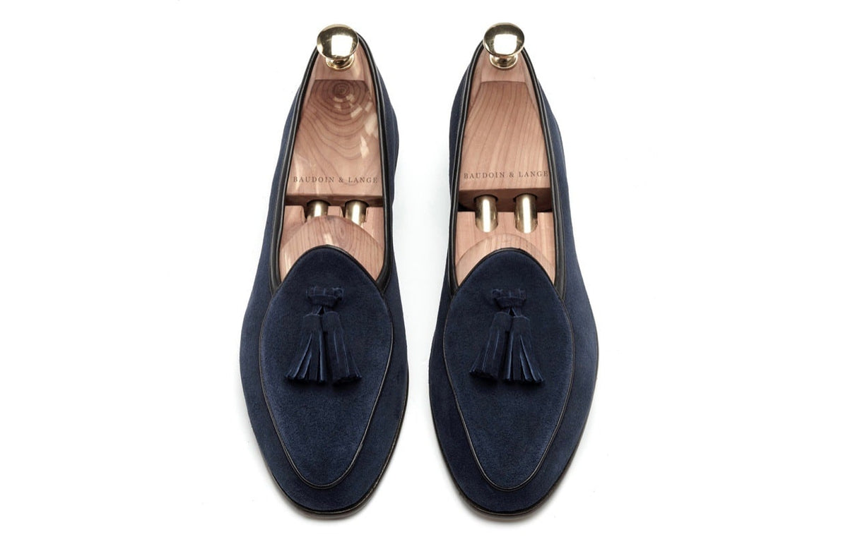 Coppia di mocassini in pelle scamosciata blu navy su sfondo bianco