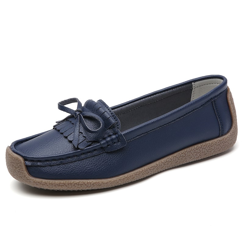 mocassino in pelle blu scuro con nappina sulla parte superiore su sfondo bianco