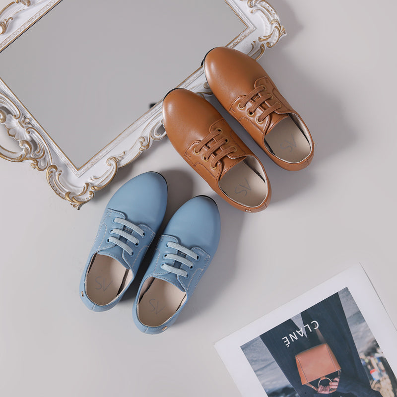 Mocassini slip-on marroni e blu in pelle sintetica per ragazzi con sfondo poster e specchio