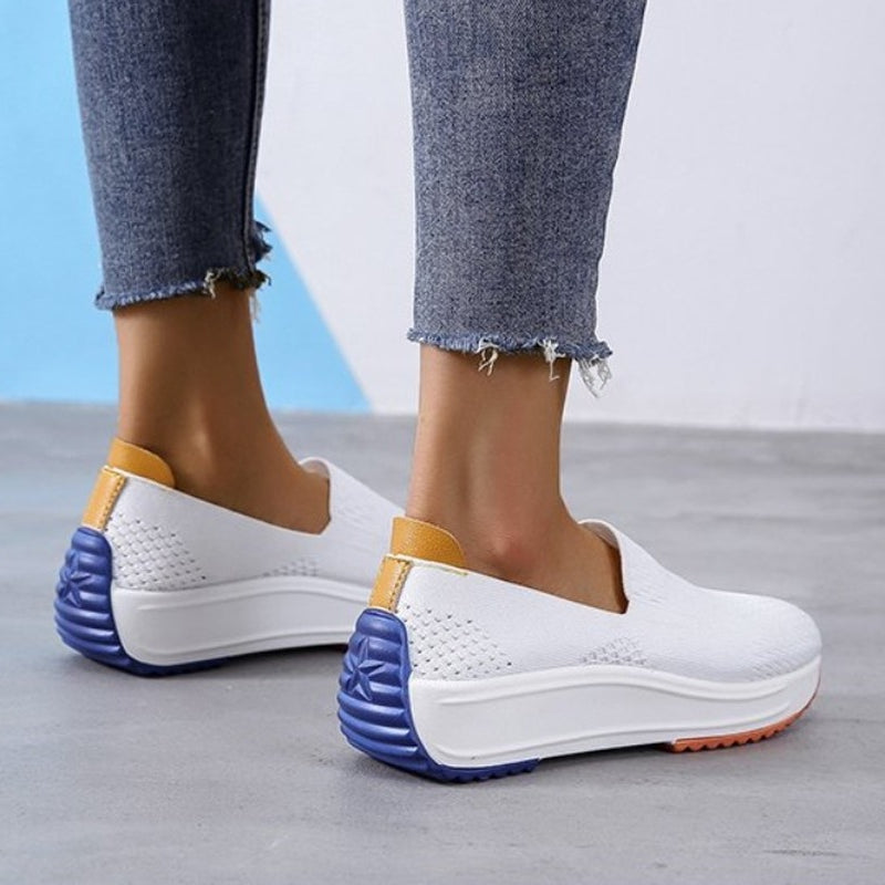 Foto di mocassini ortopedici tipo sneaker in rete bianca traspirante con suola colorata fino alla parte posteriore del tallone.