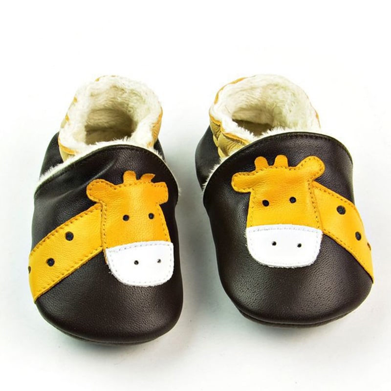 Morbidi mocassini per bambini in pelle marrone scuro con testa di giraffa gialla. Interno in morbido peluche beige.