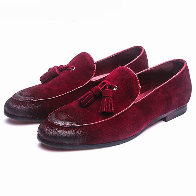 Mocassino rosso con nappina su sfondo bianco