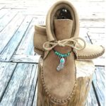 Mocassino indiano stringato in camoscio beige con gioielli etnici intorno alla caviglia