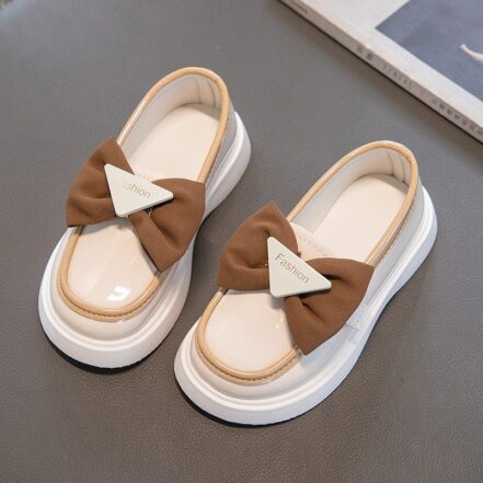 mocassino in ecopelle bianca con fiocco marrone su sfondo grigio