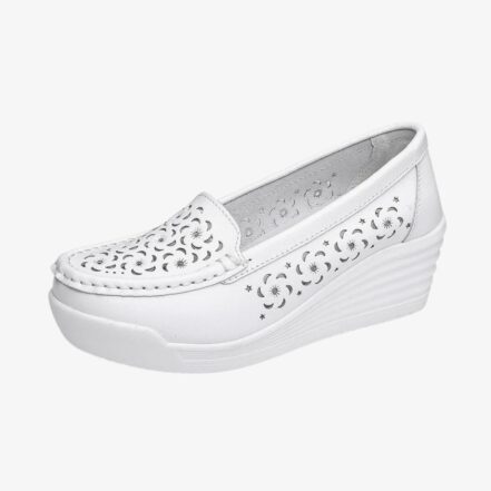 Un mocassino bianco di profilo, con suola a zeppa e fori sul davanti e sui lati.