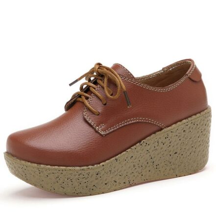 Un mocassino marrone da donna con un'ampia suola gialla