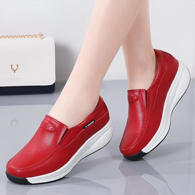 Coppia di piedi in scarpe rosse con suole bianche