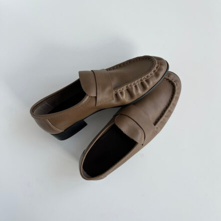 Mocassino marrone uno sopra l'altro su sfondo bianco