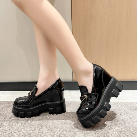 mocassino con zeppa in vernice nera indossato da una donna