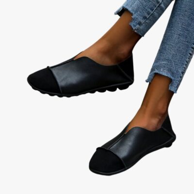 Coppia di mocassini morbidi con punta rotonda in pelle scamosciata e pelle liscia con cuciture a vista, indossati con jeans su un pavimento piastrellato grigio chiaro