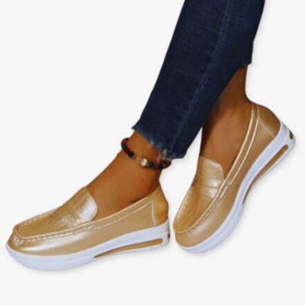 Foto di scarpe da ginnastica con zeppa in oro lucido