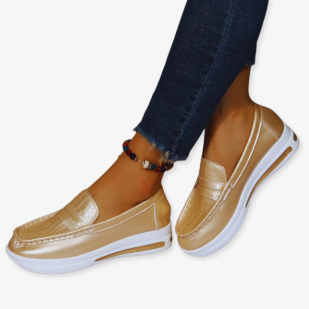 Foto di scarpe da ginnastica con zeppa in oro lucido