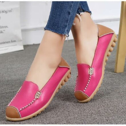 mocassino con punta tagliata a rosa, piedi su tappeto, donna con gambe incrociate