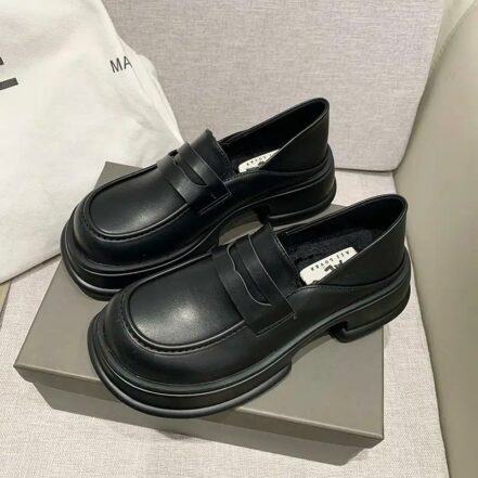 Due mocassini neri su una scatola