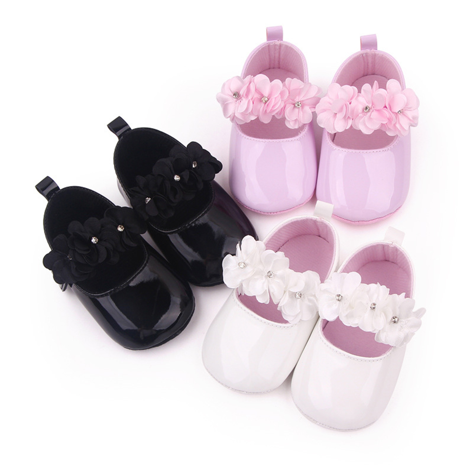 Tre paia di mocassini con fiori su sfondo bianco, in nero, rosa e bianco