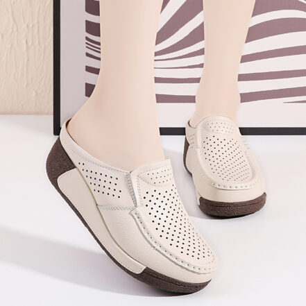 Donna in piedi che indossa mocassini con zeppa open-toe beige