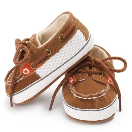 Mocassini stile barca bicolore marrone e beige con lacci su sfondo bianco