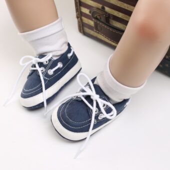 Gambe di bambino che indossano calzini bianchi e mocassini blu stile barca