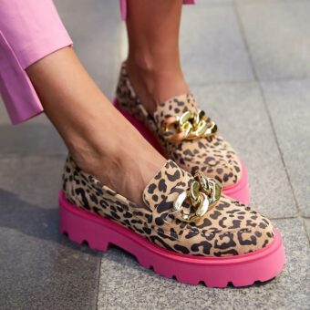 Piede di una donna che indossa pantaloni rosa e mocassini leopardati con suola rosa