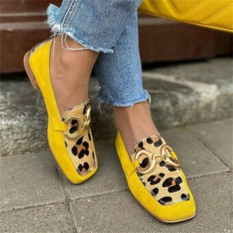 Donna in piedi in strada con jeans e mocassini gialli e leopardati a punta quadrata