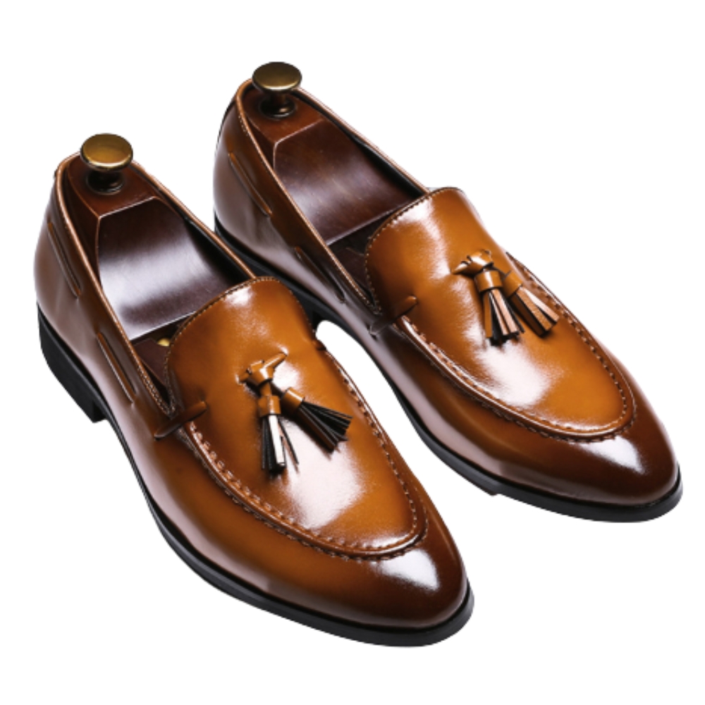 A pair of genuine leather tassel loafers for men can be seen on a brown background.
