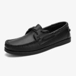 Un mocassino da barca da uomo in pelle nera su sfondo bianco