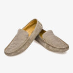 Un paio di mocassini estivi da uomo in pelle scamosciata su sfondo bianco