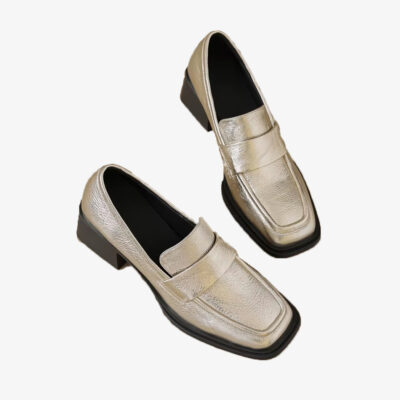 Mocassini dorati con tacco da donna su sfondo bianco