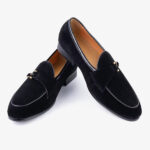 Un paio di mocassini eleganti da uomo in pelle scamosciata su sfondo bianco uniforme.