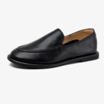 Un mocassino slipper da donna in pelle su sfondo bianco