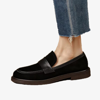 Un mocassino classico da donna in pelle scamosciata nera con cinturino, indossato con jeans